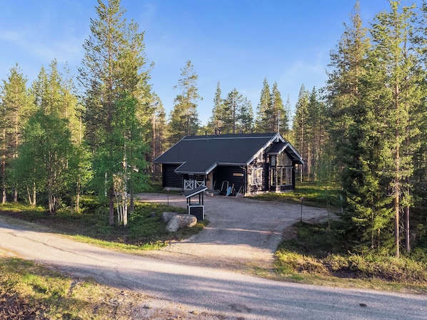 A lodge with a gravel driveway leading to a wooden building, surrounded by dense forest. - Aspilevi by Interhome (Kittilä)