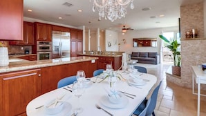 Una cocina moderna con armarios de madera, una isla central y un comedor listo para una comida.