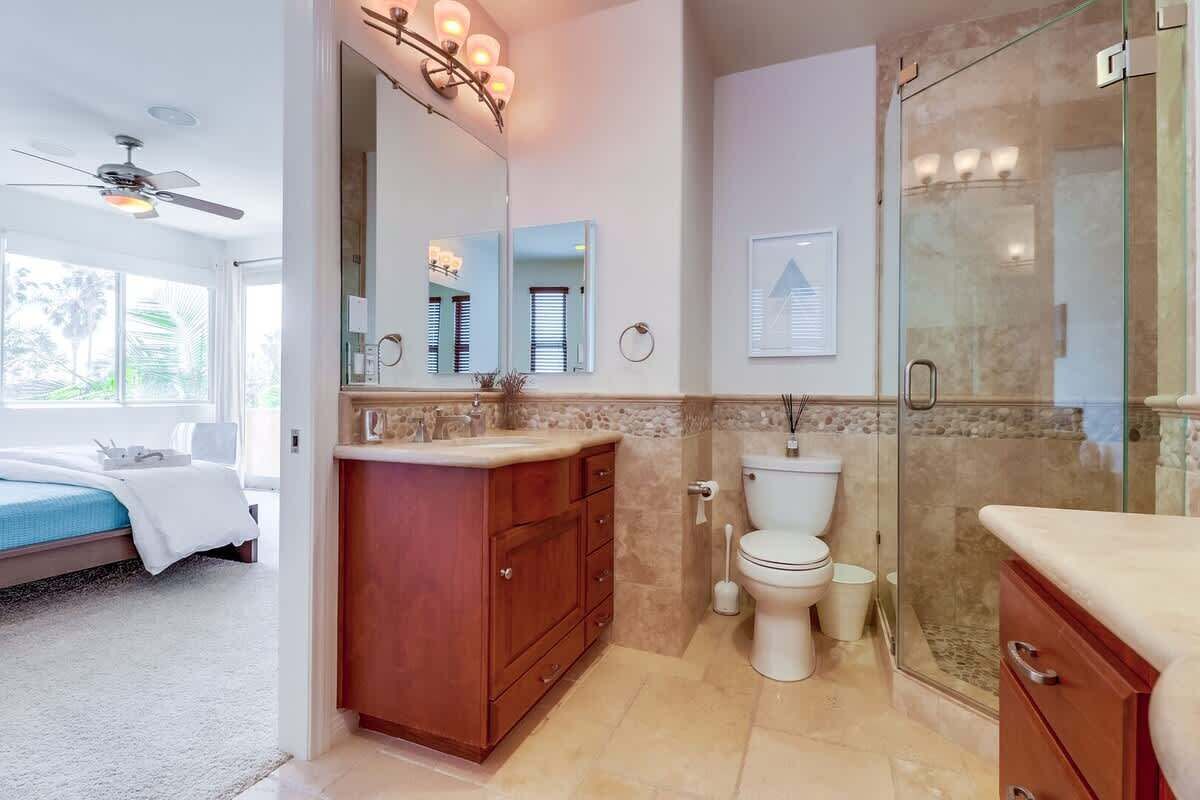 Een badkamer met douche, toilet en wastafel.
