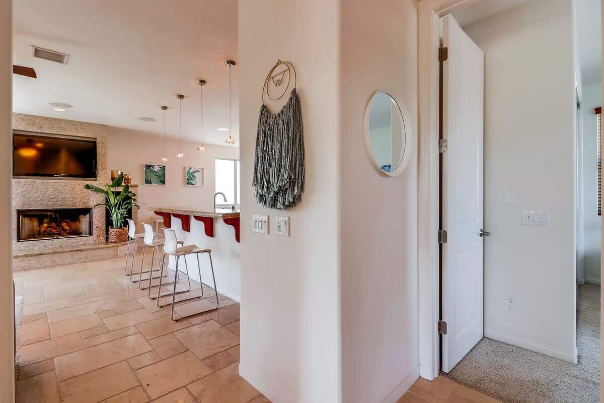 Ein modernes Wohnzimmer mit Kamin, einem Essbereich mit Stühlen und einer Küche mit Bar.