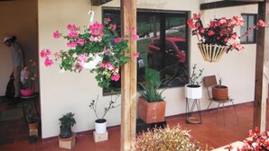 A covered patio area with potted plants and flowers. - Villa Cucha (Monguí)