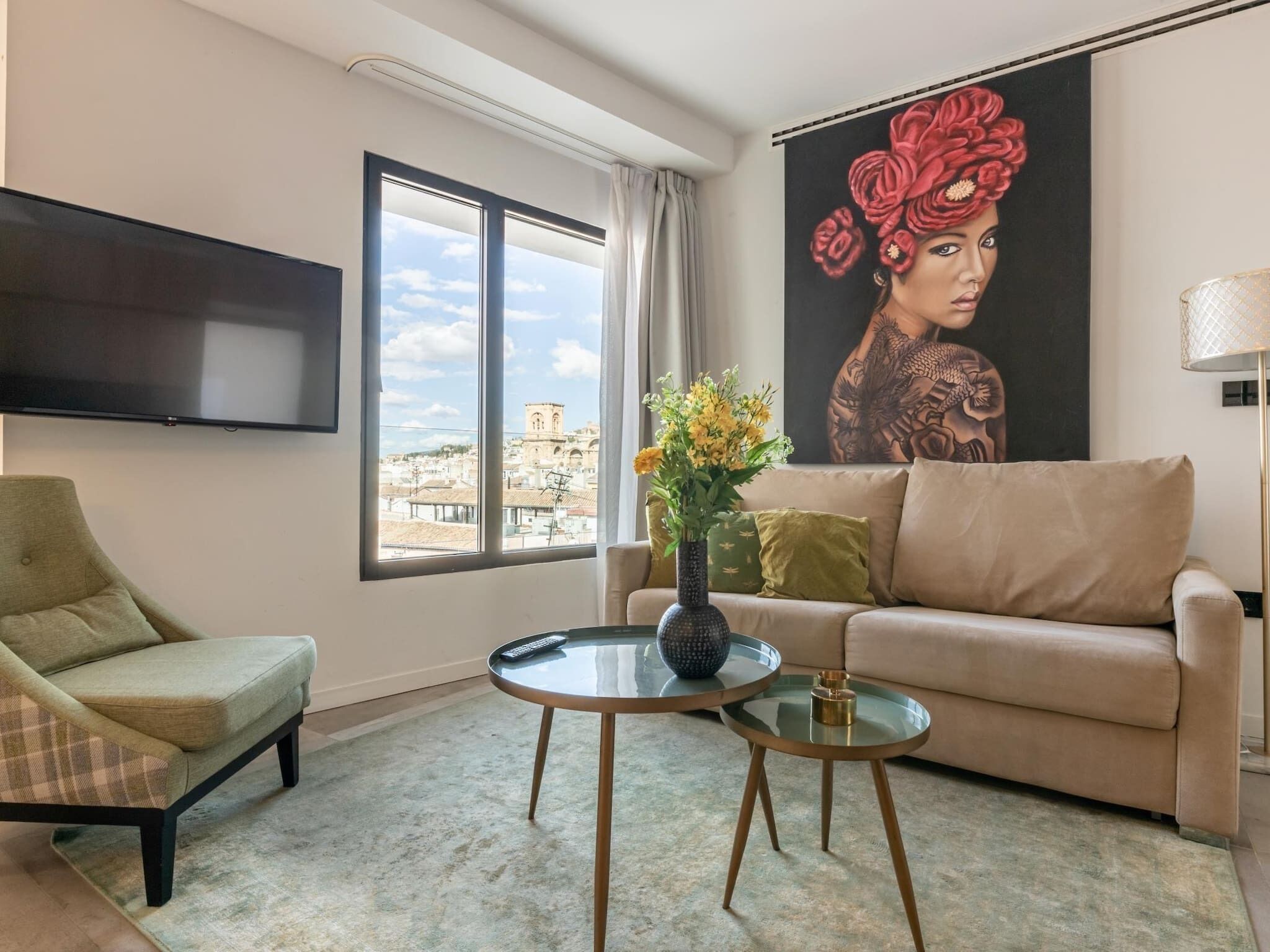 Uma sala de estar com sofá, poltrona e uma mesa de centro redonda de vidro.