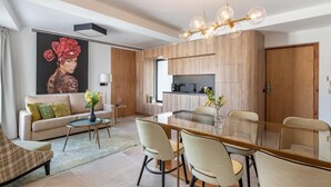 Una sala de estar moderna con comedor, que incluye un cuadro grande, un sofá, una mesa de centro y una mesa de comedor con sillas.