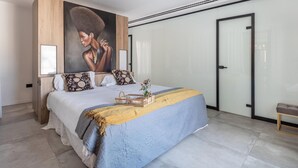 Un dormitorio moderno con una cama grande, un cuadro en la pared y un armario.