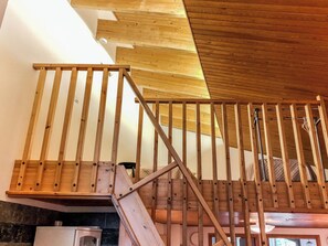 Un escalier en bois, doté d’une rampe, menant à l’étage supérieur.