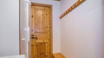 Eine Holztür mit einer Bank und einem Handtuchhalter an der Wand.