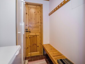 Une porte en bois, avec un banc et un porte-serviettes fixés au mur.