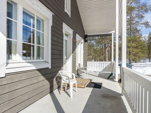 A covered porch with a table and chairs, a doormat, and a wooden bench. - Ylläskankare by Interhome (Äkäslompolo)
