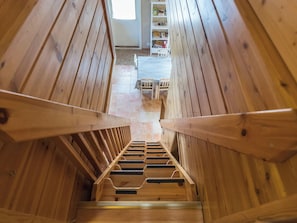 A wooden staircase with a view of a room at the top.
