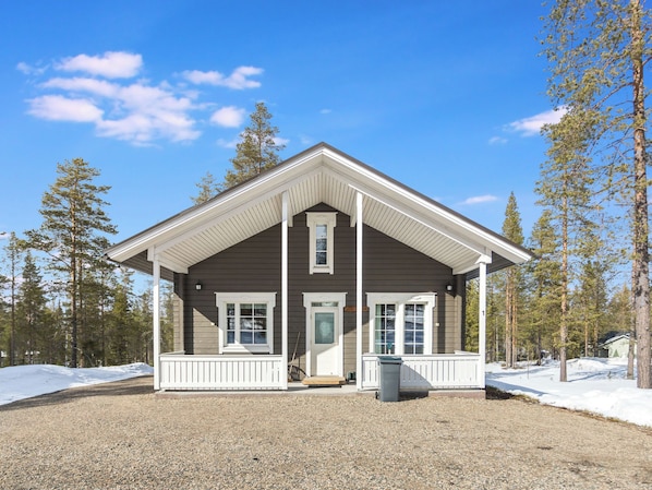 A two-story house with a covered porch, a front door, and a small front yard.