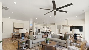 A spacious living room with a large sofa, coffee table, and a ceiling fan. - Golf Course Views, Private Pool, Hot Tub, Fire Pit (Washington)
