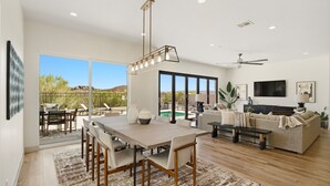 A spacious living area with a dining table, sofas, and a TV. - Golf Course Views, Private Pool, Hot Tub, Fire Pit (Washington)