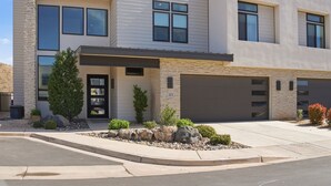 A modern two-story building with a garage, a stone facade, and a landscaped front yard. - Golf Course Views, Private Pool, Hot Tub, Fire Pit (Washington)