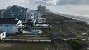 A beachfront property with a swimming pool, multiple balconies, and a boardwalk leading to the beach. - Wake up to the sunrise over the Atlantic! Beautiful ocean views from balcony  (North Myrtle Beach)
