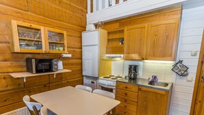 Une cuisine de taille réduite, dotée de meubles en bois, d’un four à micro-ondes, d’un réfrigérateur, d’une cuisinière et d’un évier.