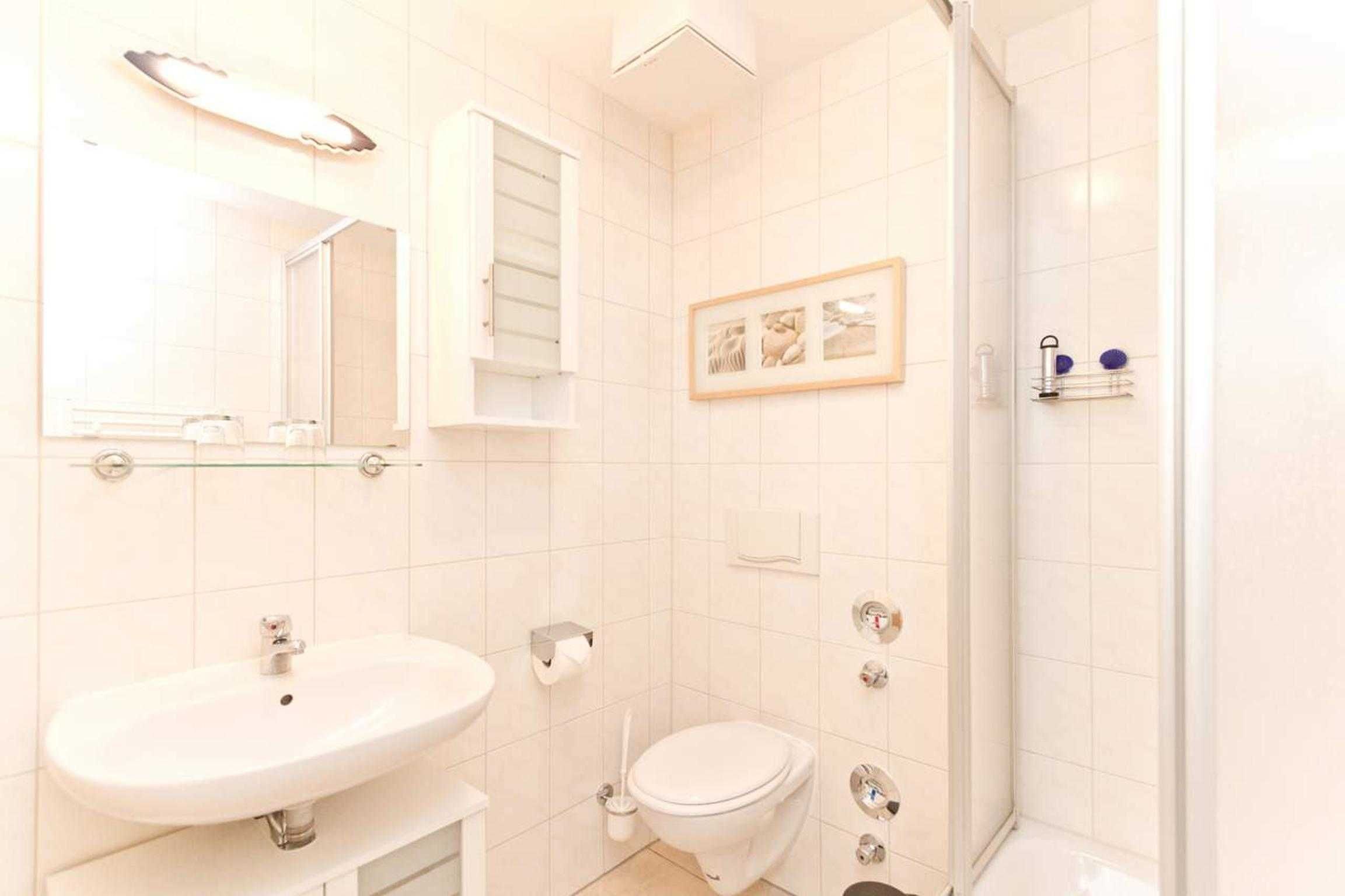 A bathroom with a sink, toilet, and shower.