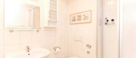 A bathroom with a sink, toilet, and shower.