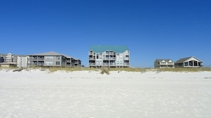 Ein Anwesen direkt am Strand mit mehreren Gebäuden, darunter ein großes, zentrales Hauptgebäude mit Gründach und einige kleinere Bauten.