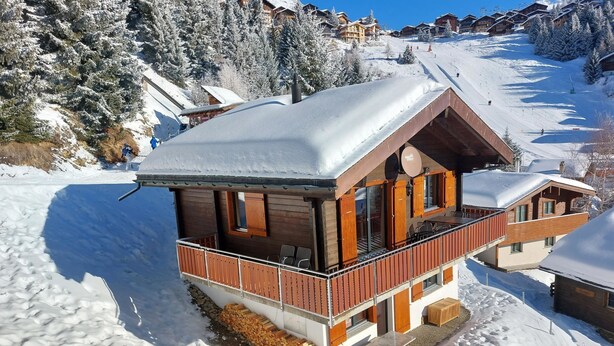 A chalet-style building with a balcony, situated on a snow-covered slope with ski slopes in the background. - Brunnquell by Interhome (Bettmeralp)