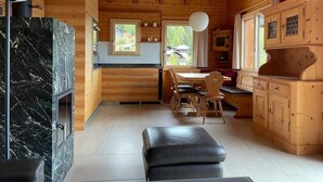 A wooden cabin interior with a kitchen, dining area, and a fireplace. - Brunnquell by Interhome (Bettmeralp)