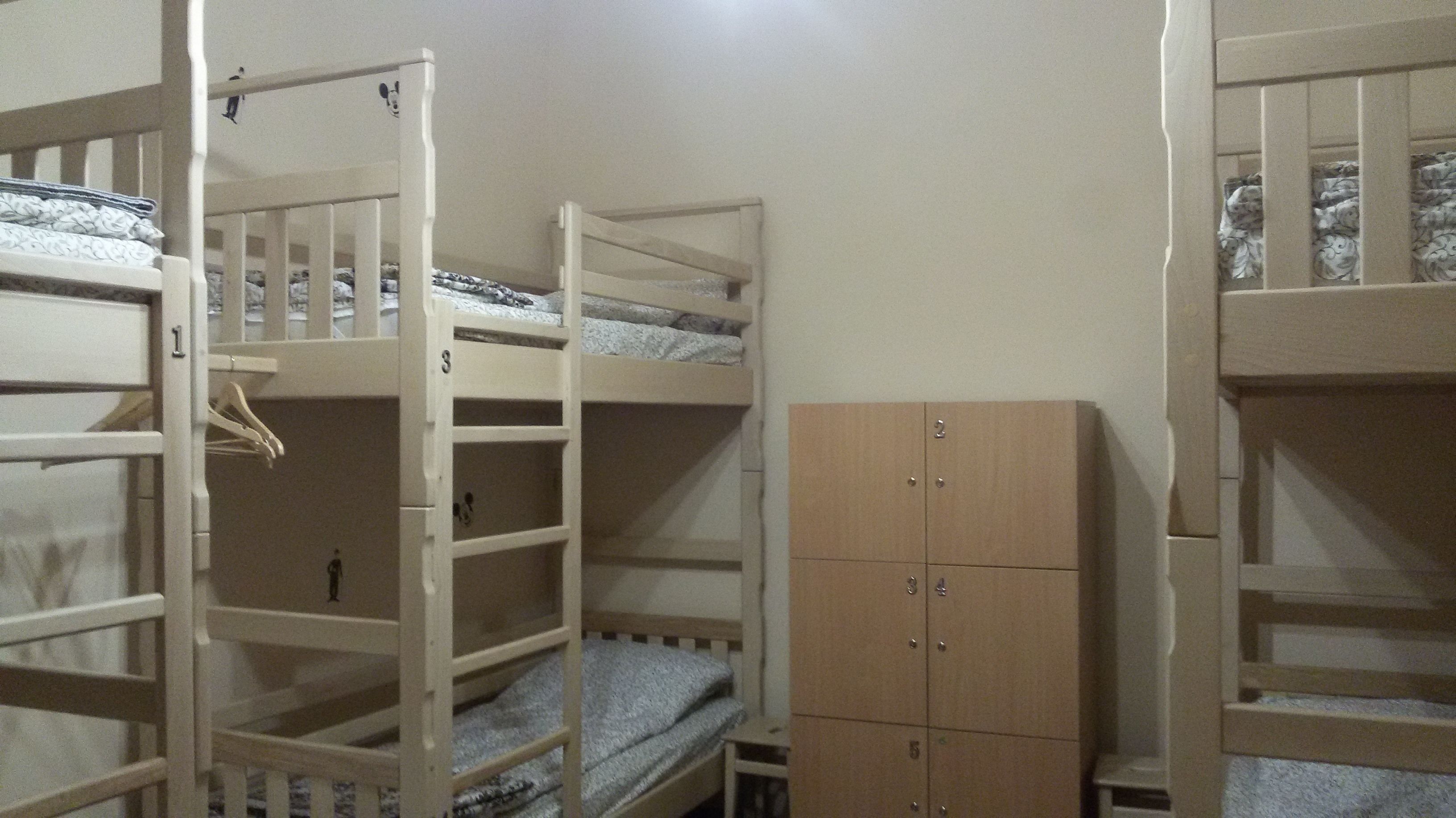A bunk bed room with a wooden wardrobe.
