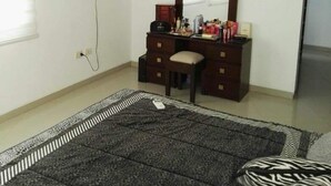 A bedroom with a bed, a dresser, a television mounted on the wall, and a window. - Santa Cruz Furnished Department (Santa Cruz)