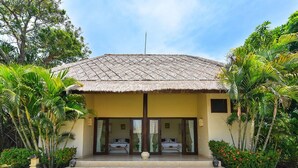 A two-story building with a thatched roof, a central staircase, and two visible bedrooms with beds. - Villa Lotus - Let The Sea Set You Free (Seririt)