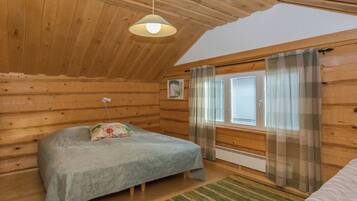 Une chambre confortable avec un lit, une fenêtre avec des rideaux, un radiateur et un luminaire au plafond.