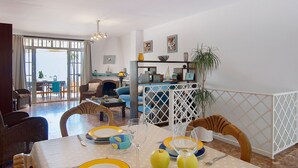 A dining area with a table set for four, a sofa, and a fireplace. - Vacation home Amanda by Interhome (Nerja)