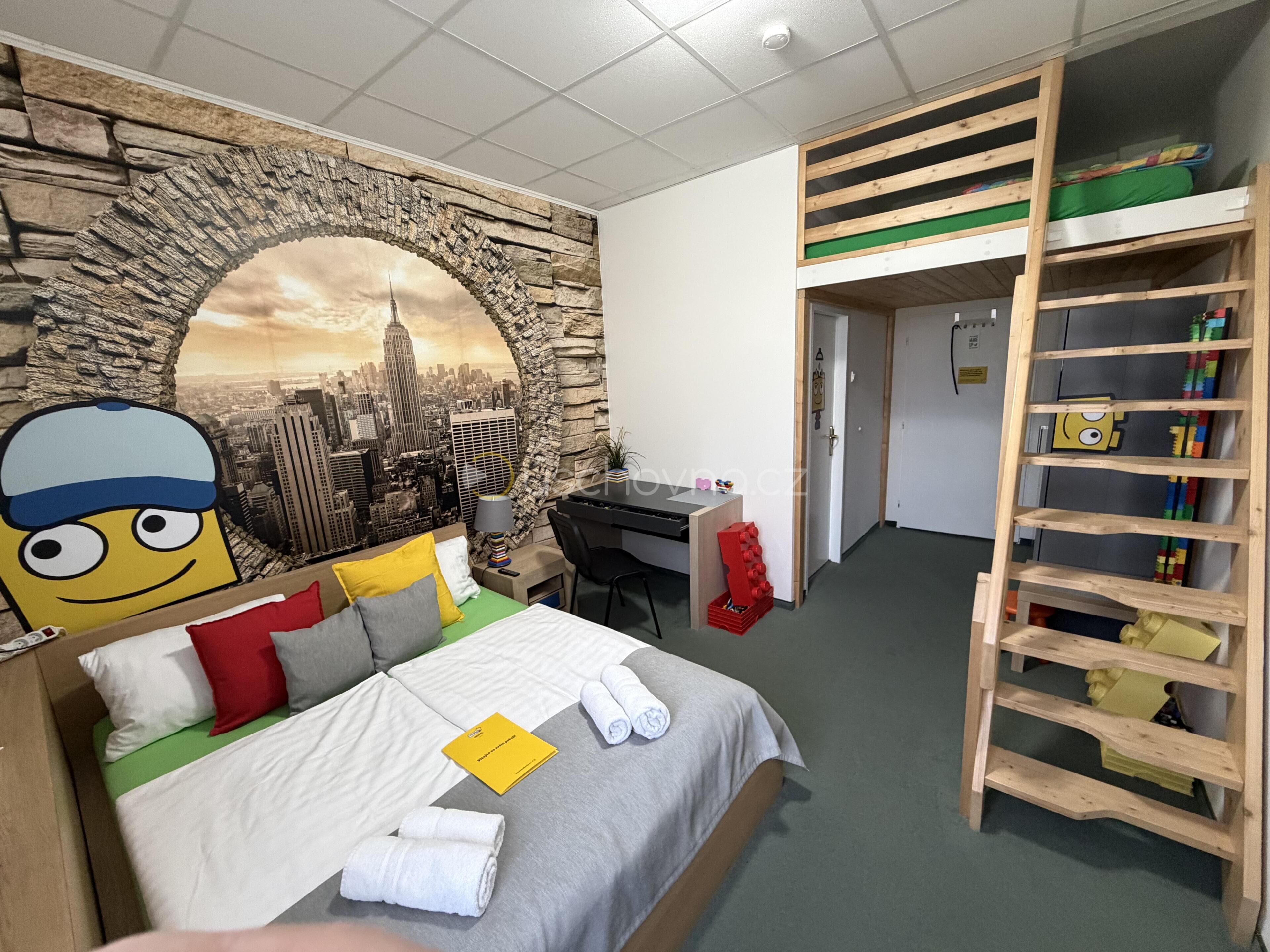 A hotel room with a bed, a desk, and a wardrobe.