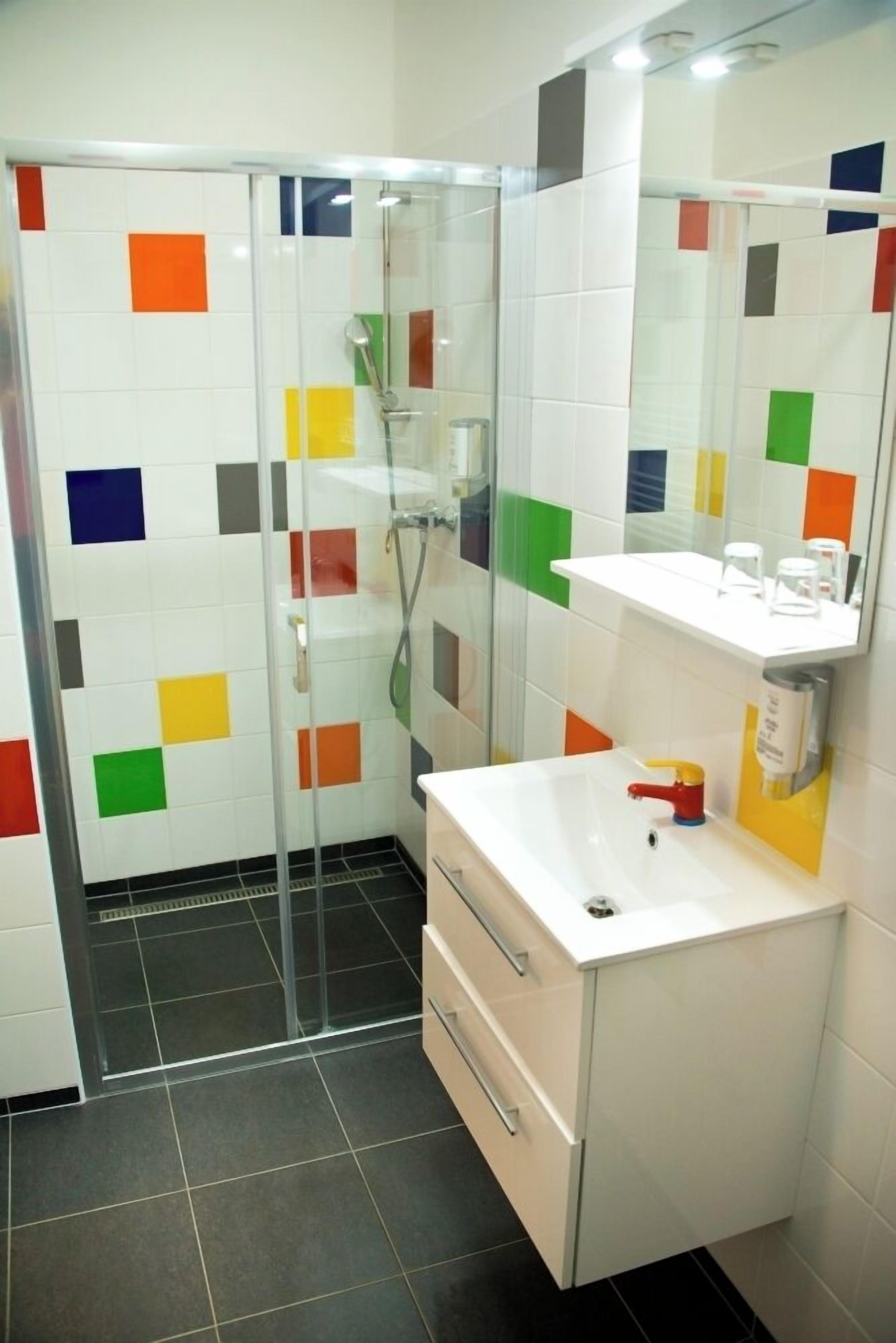 A bathroom with a shower, a sink, and a mirror.