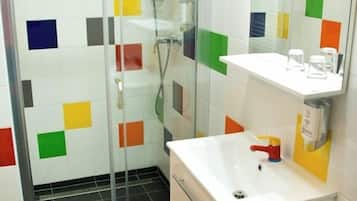 A bathroom with a shower, a sink, and a mirror.