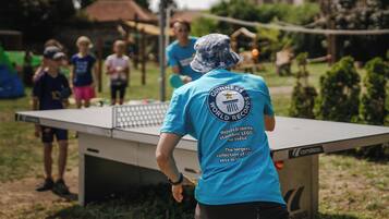 A person in a blue shirt with a Guinness World Records logo, standing in front of a ping pong table.