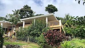 Una casa con terraza de madera y patio cercado.