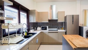 Una cucina moderna con forno a microonde, tostapane, lavello ed elettrodomestici in acciaio inossidabile.