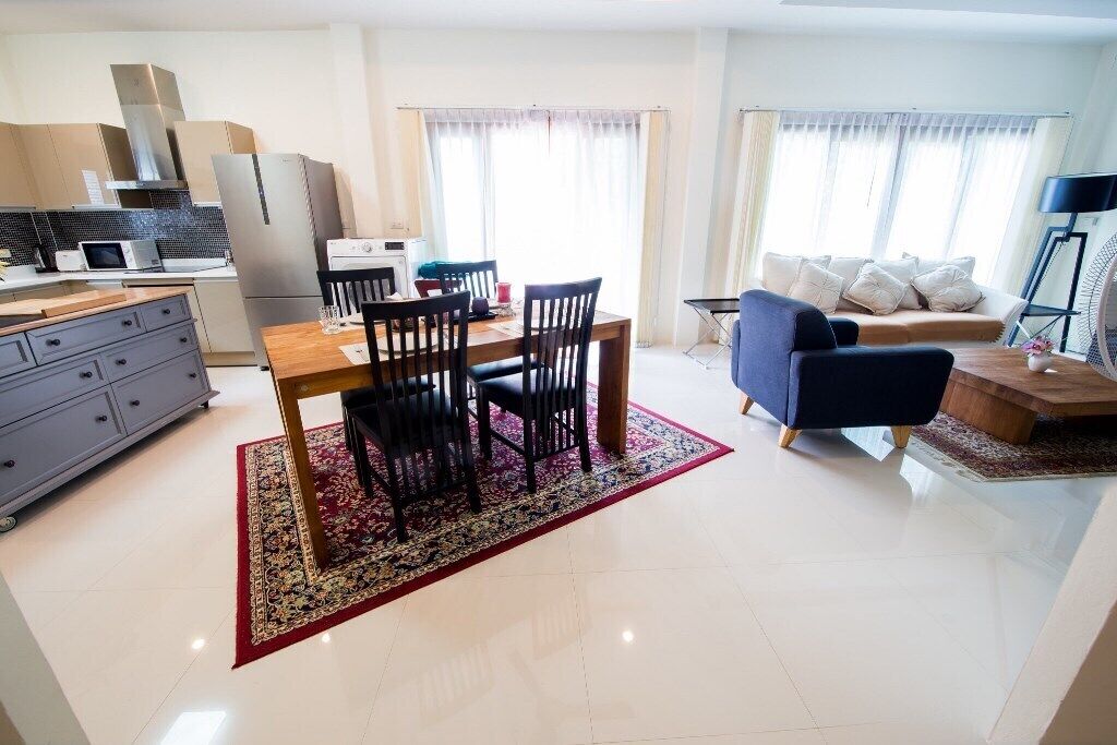 A modern apartment with a kitchen, dining area, and living room.