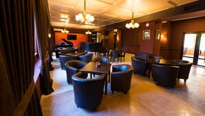 Un restaurante con varias mesas y sillas, un piano y una zona de bar.