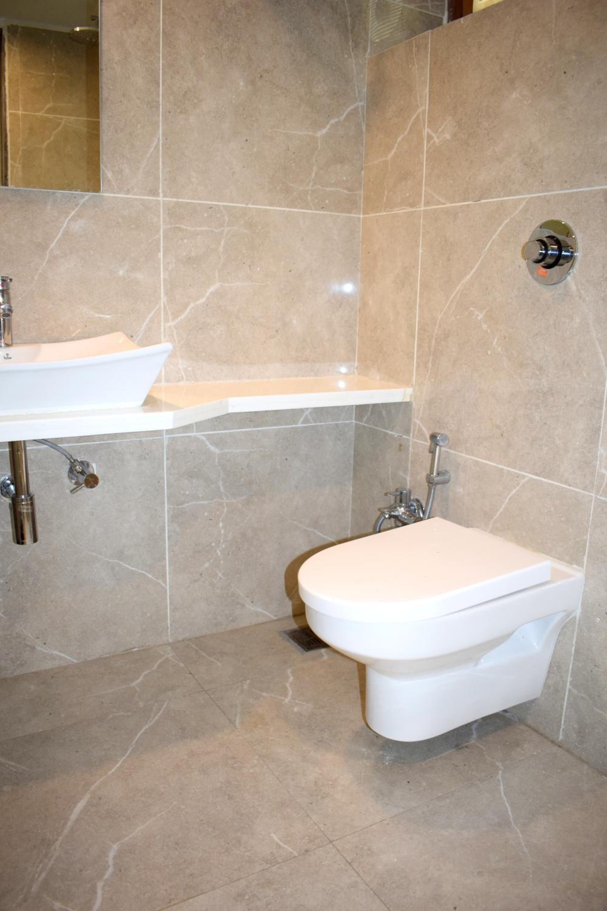 A bathroom with a white sink, a toilet, and a shower area.