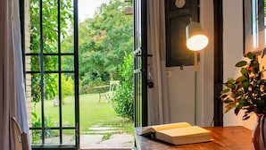 Una habitación con una mesa de madera, un banco, un libro y una planta en maceta.