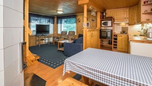 A cozy cabin interior with a living area, dining table, kitchen, and wooden ceiling. - Joutsen by Interhome (Kouvola)