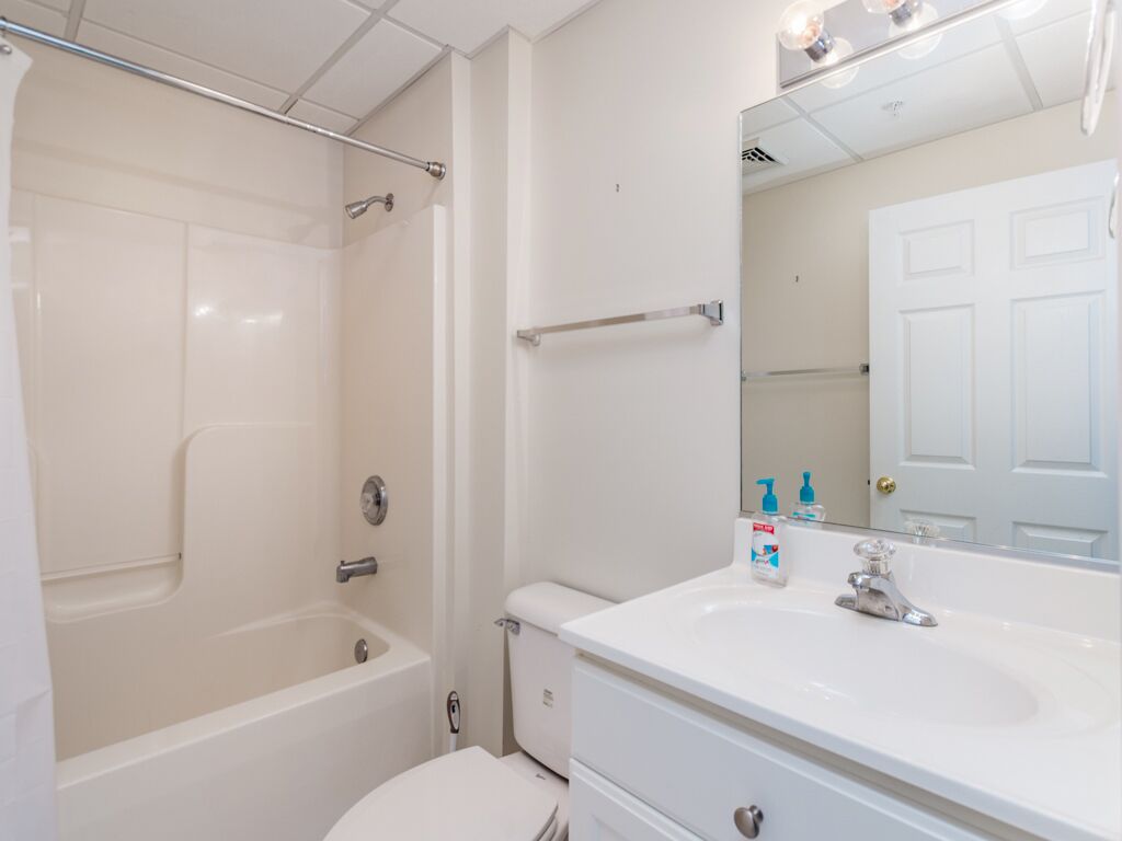 Une salle de bain avec une baignoire, des toilettes, un lavabo et un miroir.