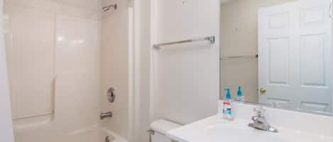 Une salle de bain avec une baignoire, des toilettes, un lavabo et un miroir.