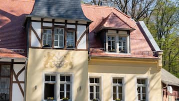 Ein traditionelles Gebäude mit einem markanten Turm, zahlreichen Fenstern und einem Schild, das ein Restaurant anzeigt.