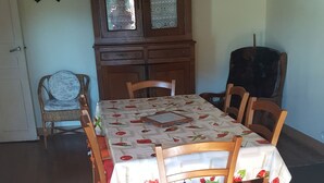 Un coin repas avec une table et des chaises en bois, un buffet et une horloge au mur.