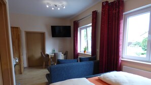 A hotel room with a bed, a desk, a chair, and a TV. - Hotel Landhaus Effeld (Wassenberg)
