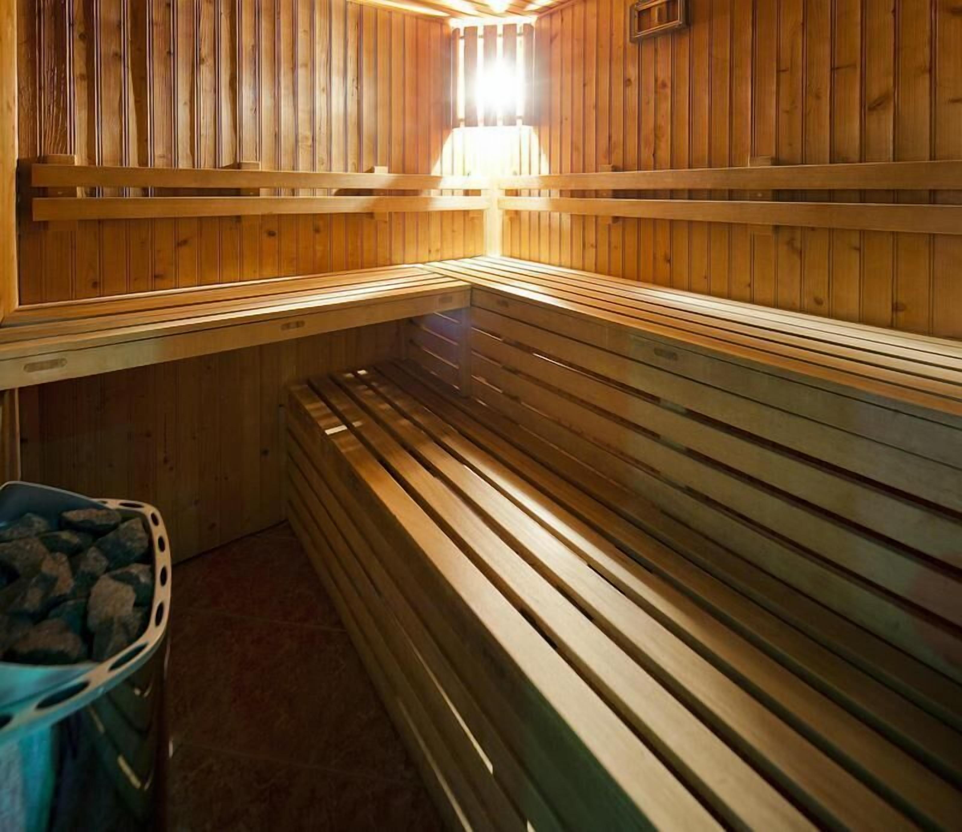A sauna with wooden benches and a stone basin.