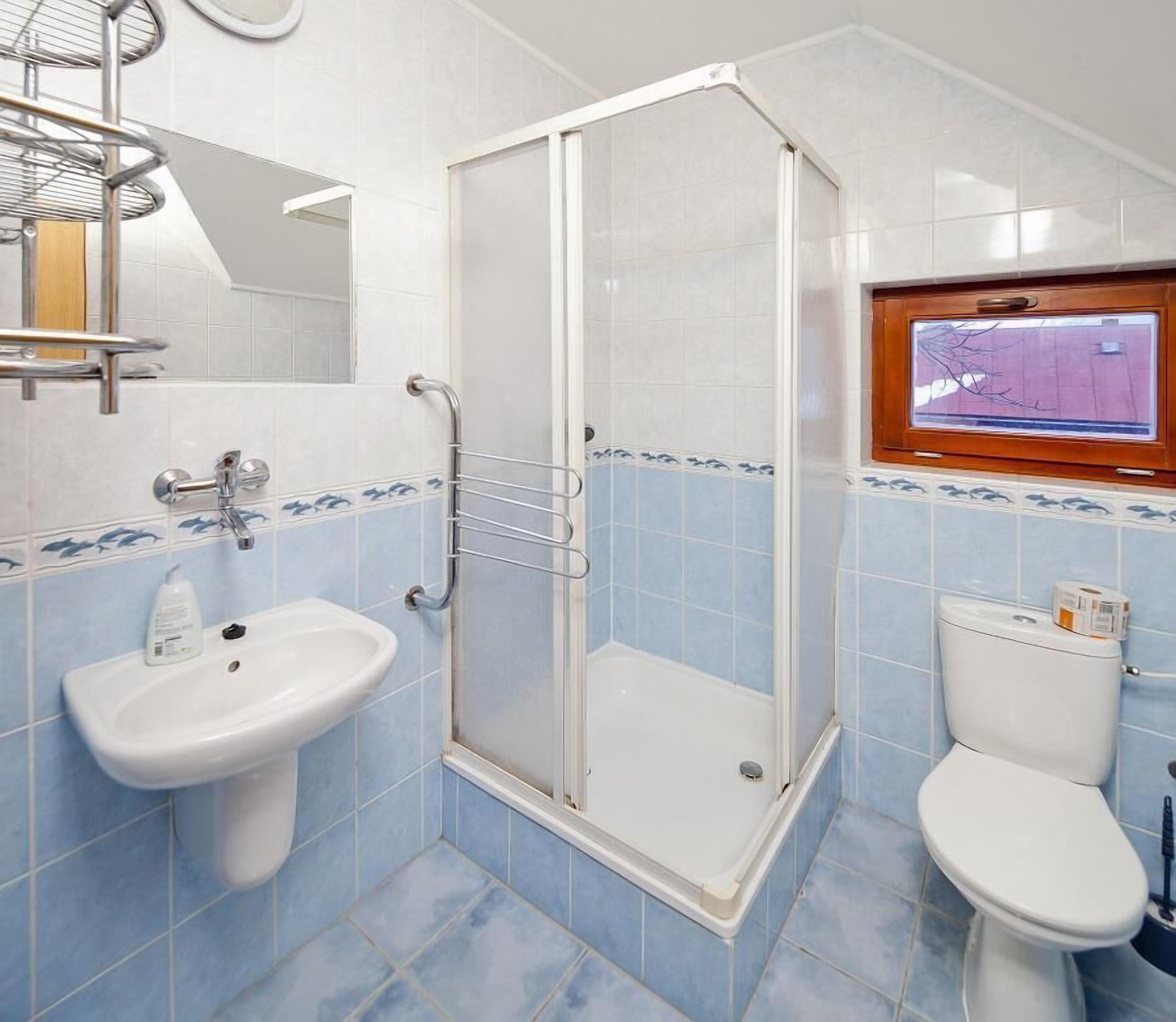 A bathroom with a shower, sink, and toilet.