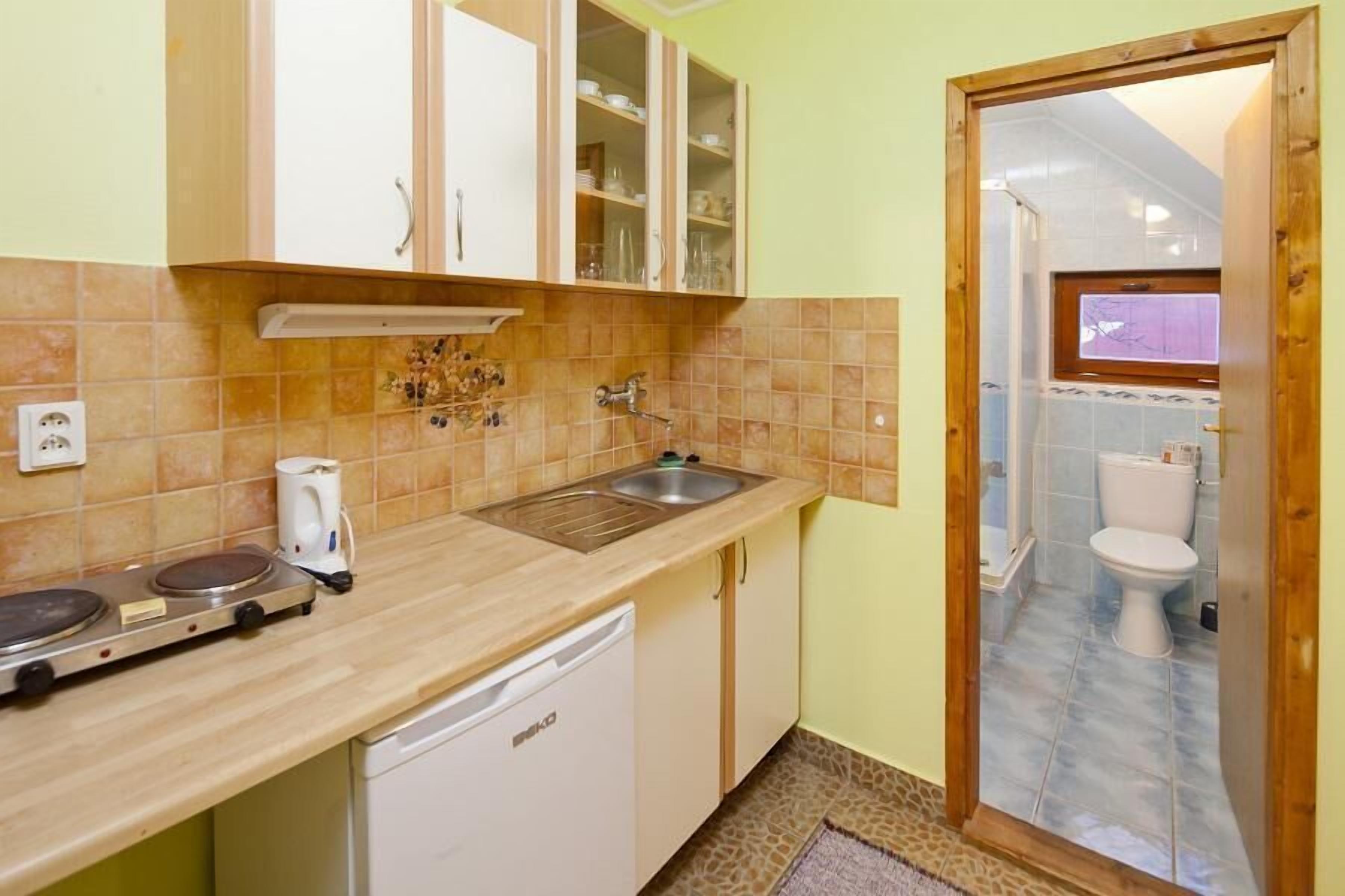A compact kitchen with a dishwasher, a coffee maker, and a stove.