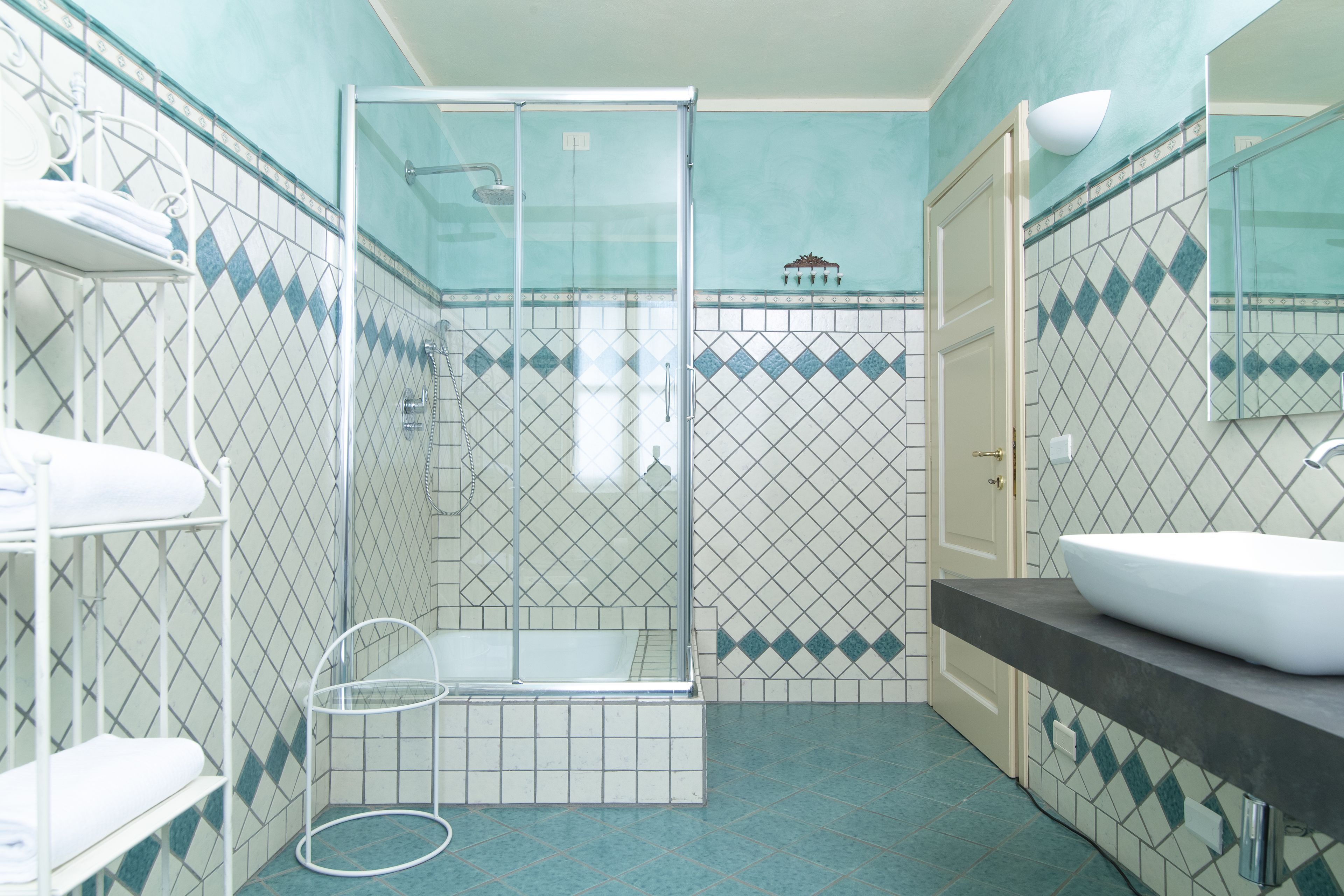 A bathroom with a shower, a sink, and a mirror.