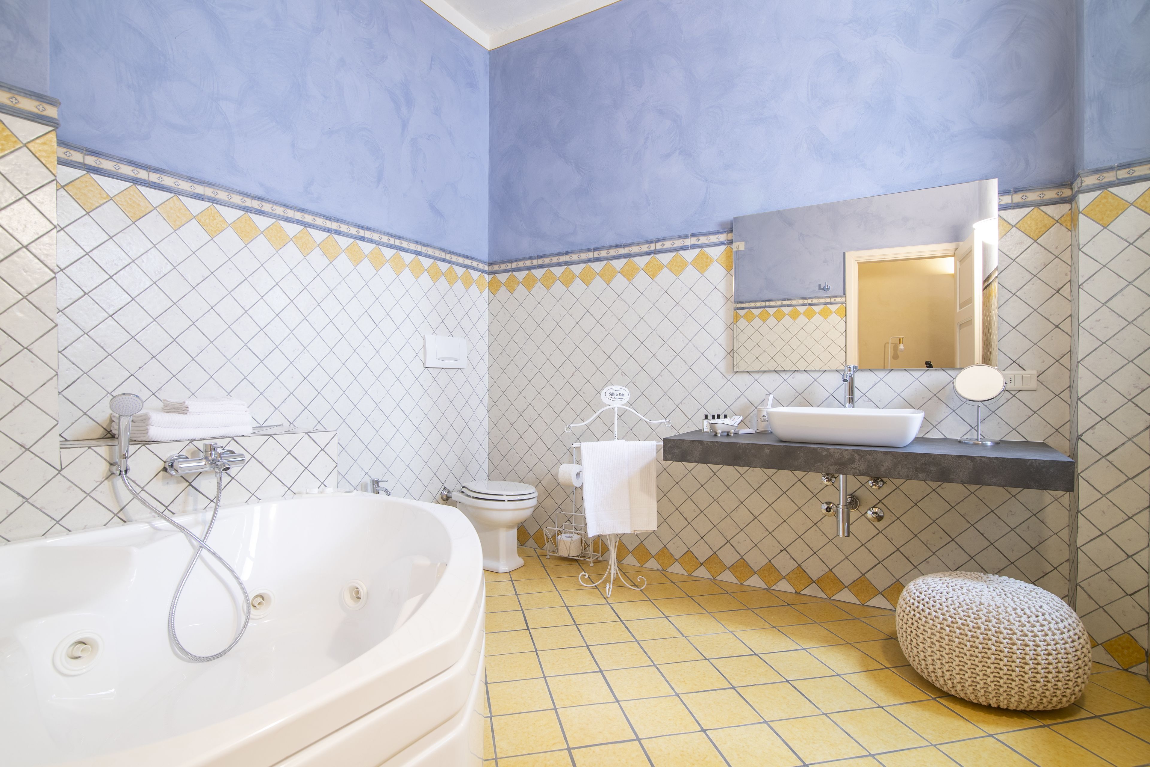A bathroom with a bathtub, toilet, sink, and mirror.